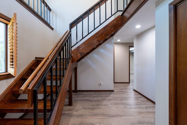 stairway featuring baseboards, recessed lighting, and wood finished floors