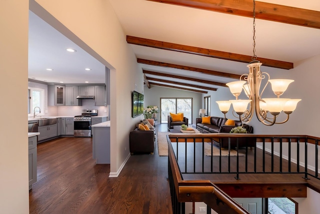 dining space featuring a notable chandelier, lofted ceiling with beams, dark wood finished floors, recessed lighting, and baseboards