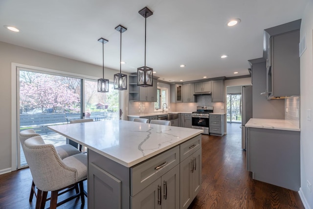 kitchen with a center island, gray cabinets, and appliances with stainless steel finishes