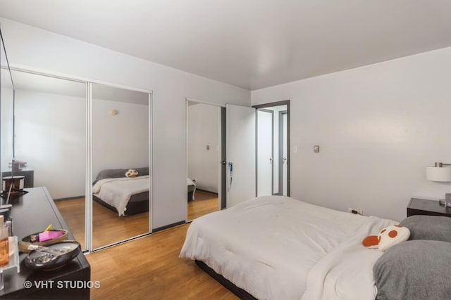 bedroom with light wood-type flooring and multiple closets