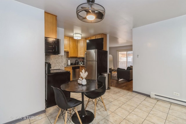 dining room featuring baseboards, a baseboard heating unit, and light tile patterned floors