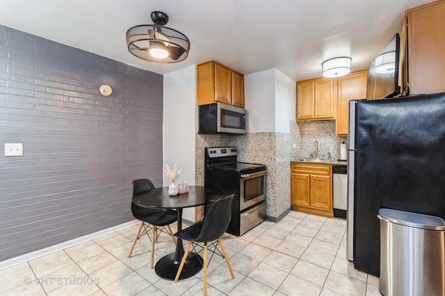 7428 Washington St Unit 304, Forest Park, IL 60130 - kitchen featuring appliances with stainless steel finishes, light tile patterned floors, a sink, and brick wall
