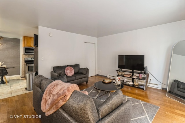 living room with light wood-style flooring and baseboard heating