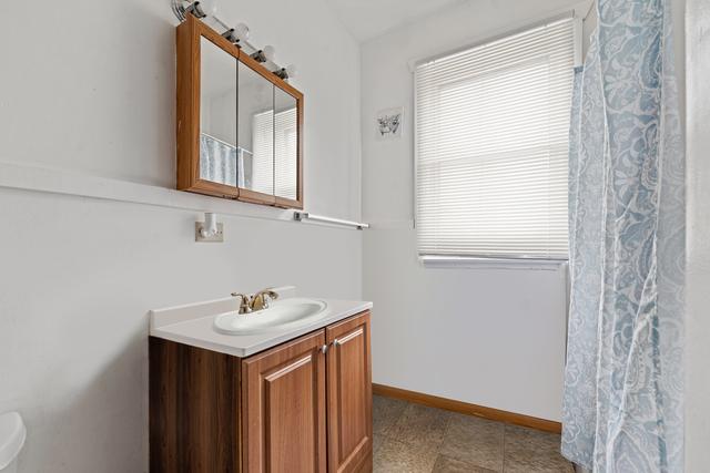 98 W 15th St, Chicago Heights, IL 60411 - full bath featuring a shower with curtain, vanity, and baseboards