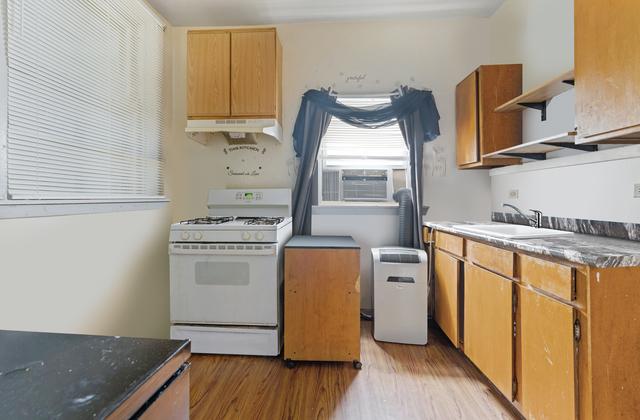 98 W 15th St, Chicago Heights, IL 60411 - kitchen featuring a sink, under cabinet range hood, open shelves, white gas stove, and light wood-style flooring