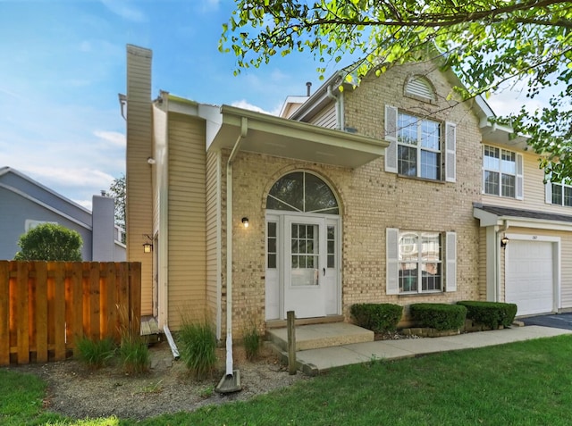 traditional home with a chimney, brick siding, and fence