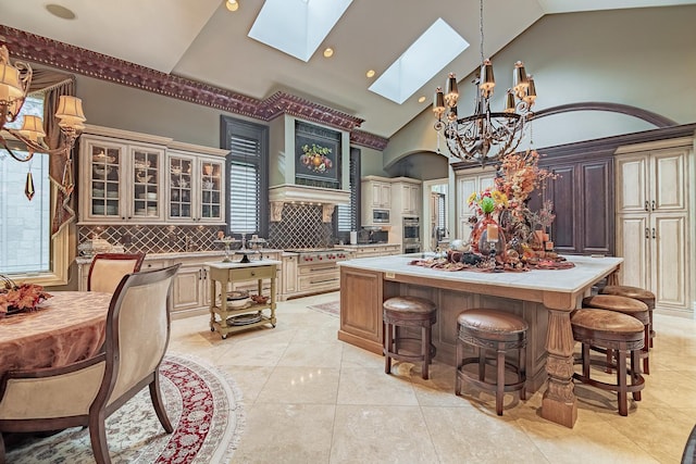 113 Carmela Ct, Bloomingdale, IL 60108 - kitchen with a chandelier, a skylight, a kitchen island, light countertops, and cream cabinetry