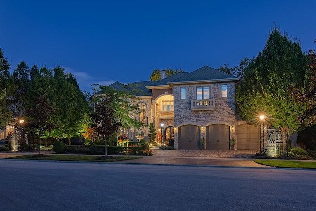 113 Carmela Ct, Bloomingdale, IL 60108 - view of front of home with a balcony, a chimney, decorative driveway, and stone siding