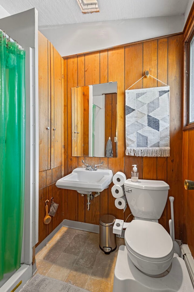 2110 Heather Rd, Geneva, IL 60134 - full bath with toilet, a baseboard heating unit, a sink, a shower stall, and stone finish flooring