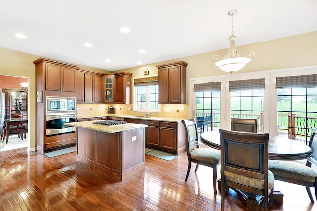 35 Open Pkwy N, Hawthorn Woods, IL 60047 - kitchen featuring stainless steel appliances, a sink, a center island, wood-type flooring, and glass insert cabinets