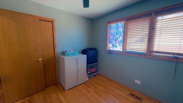 laundry area featuring visible vents, a ceiling fan, and light wood finished floors