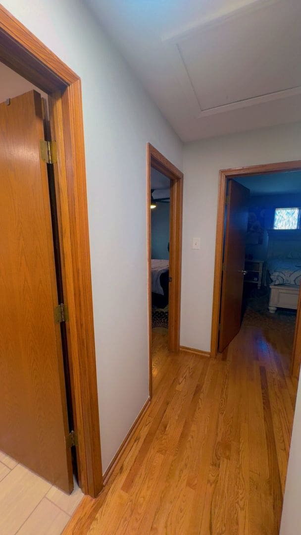 corridor featuring attic access and light wood-style floors
