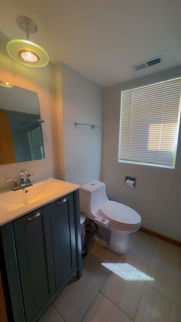 bathroom featuring baseboards, visible vents, toilet, and vanity