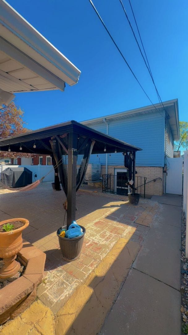 view of patio featuring fence, a gazebo, and a gate