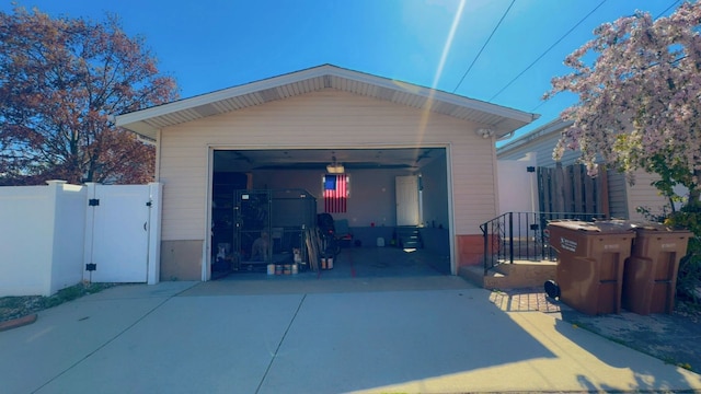detached garage featuring fence and a gate