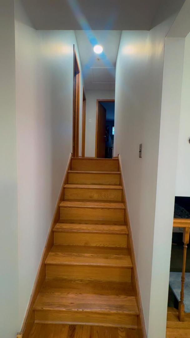 stairway with wood finished floors and baseboards