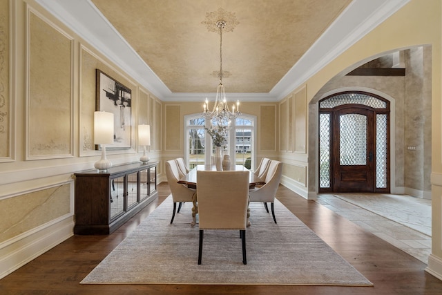 26W051 W Mohican Dr, Wheaton, IL 60189 - dining area featuring dark wood-type flooring, a decorative wall, a notable chandelier, and arched walkways