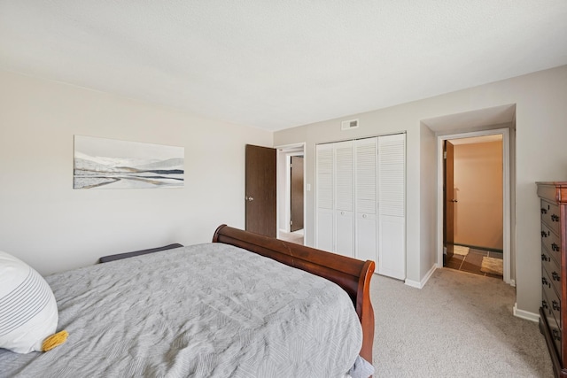 bedroom featuring baseboards, visible vents, light carpet, and a closet