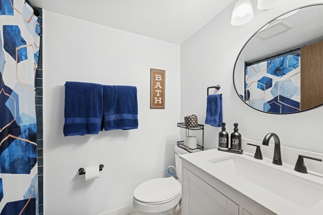 bathroom with toilet, curtained shower, and vanity