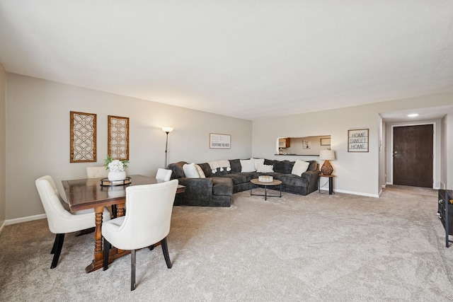 carpeted living area with baseboards