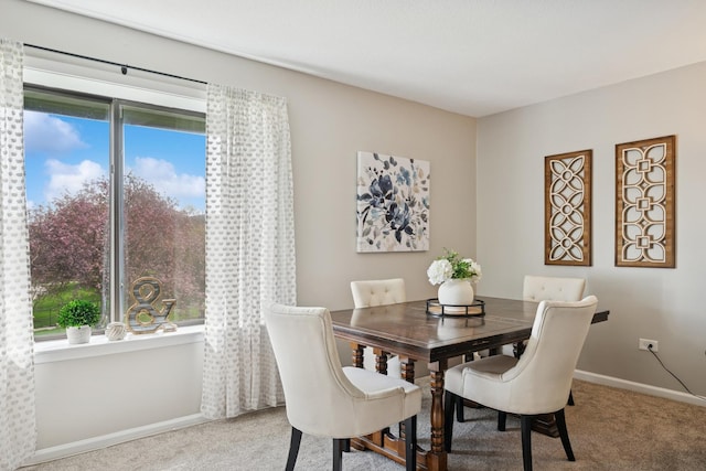 dining space with baseboards, carpet flooring, and a wealth of natural light
