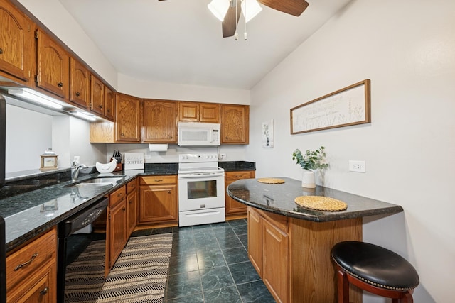 kitchen with brown cabinetry, a ceiling fan, a breakfast bar, white appliances, and a sink