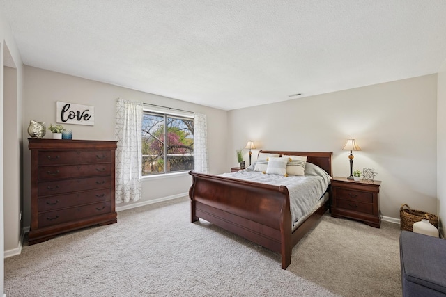 bedroom featuring baseboards, a textured ceiling, and carpet