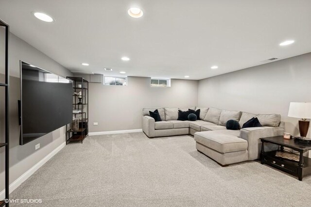 carpeted living area featuring baseboards and recessed lighting