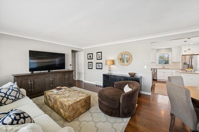 living room featuring dark wood-type flooring, baseboards, and crown molding