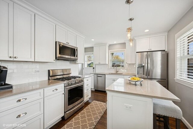 kitchen featuring a sink, stainless steel appliances, dark wood-style floors, and a wealth of natural light