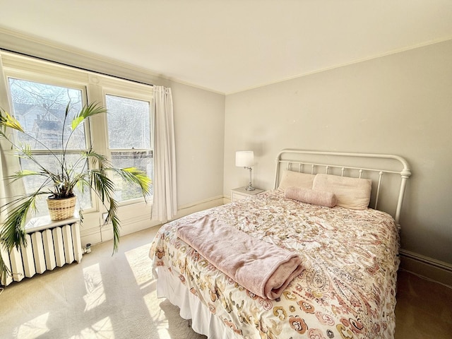 bedroom with crown molding, carpet flooring, and radiator