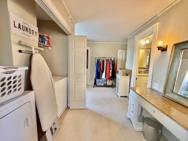 laundry area featuring light colored carpet, ornamental molding, laundry area, and washing machine and dryer