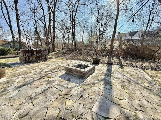 view of patio / terrace featuring fence, a fire pit, and outdoor dry bar