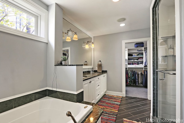 full bathroom featuring vanity, recessed lighting, a bath, a spacious closet, and a shower with shower door
