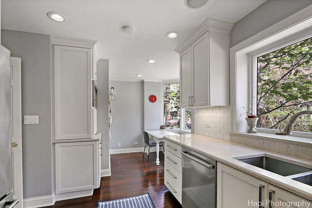 kitchen featuring a sink, plenty of natural light, backsplash, and dishwasher