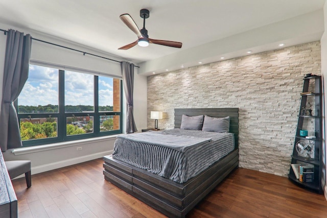 bedroom with hardwood / wood-style floors, a ceiling fan, and baseboards