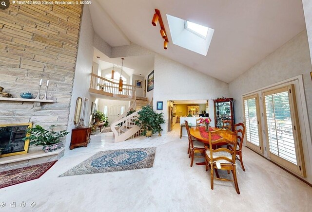 18W742 60th St, Westmont, IL 60559 - dining area featuring high vaulted ceiling, stairs, a stone fireplace, carpet, and a skylight