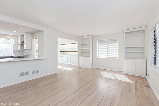 127 Riverside Dr, Northfield, IL 60093 - unfurnished living room with baseboards, visible vents, a healthy amount of sunlight, and light wood-style flooring