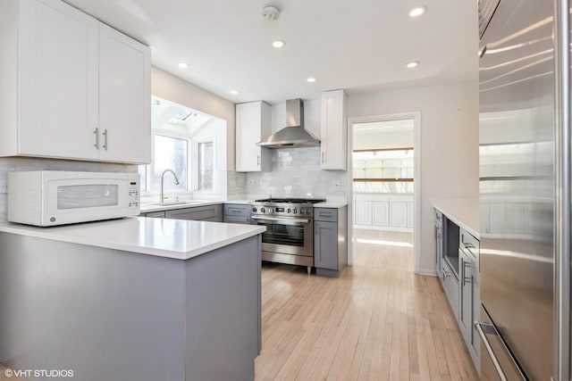 127 Riverside Dr, Northfield, IL 60093 - kitchen featuring tasteful backsplash, a sink, gray cabinetry, wall chimney exhaust hood, and high end appliances