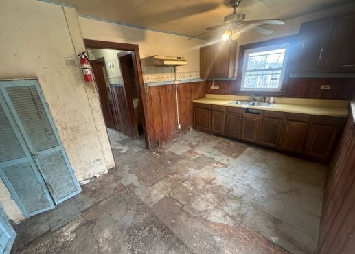 14717 E Riverside Dr, South Holland, IL 60473 - kitchen featuring a sink, ceiling fan, a wainscoted wall, wooden walls, and light countertops