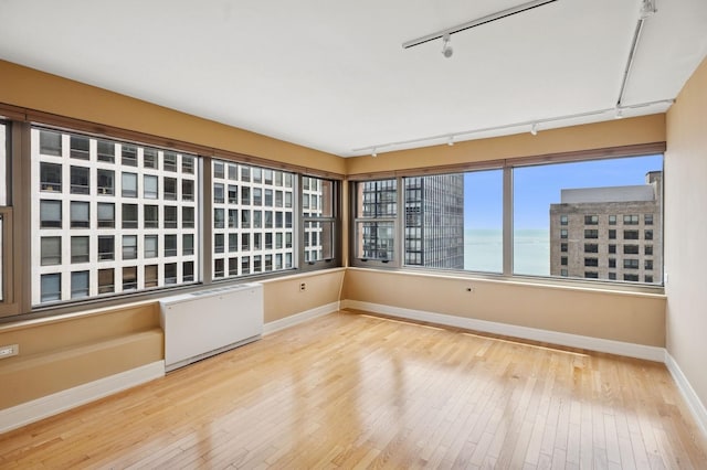 247 E Chestnut St Unit 2303, Chicago, IL 60611 - unfurnished sunroom featuring track lighting, radiator, and a water view