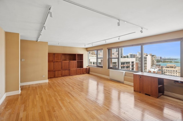 247 E Chestnut St Unit 2303, Chicago, IL 60611 - unfurnished living room with rail lighting, baseboards, light wood-style flooring, and a view of city