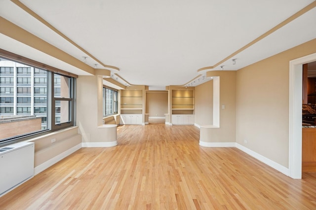 247 E Chestnut St Unit 2303, Chicago, IL 60611 - unfurnished living room with radiator, wood finished floors, and baseboards