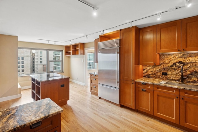 247 E Chestnut St Unit 2303, Chicago, IL 60611 - kitchen featuring open shelves, stainless steel built in fridge, track lighting, and a sink
