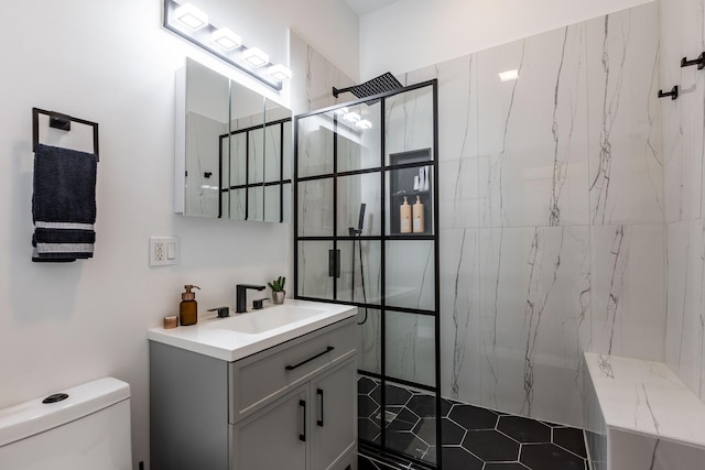 full bathroom with toilet, a marble finish shower, and vanity