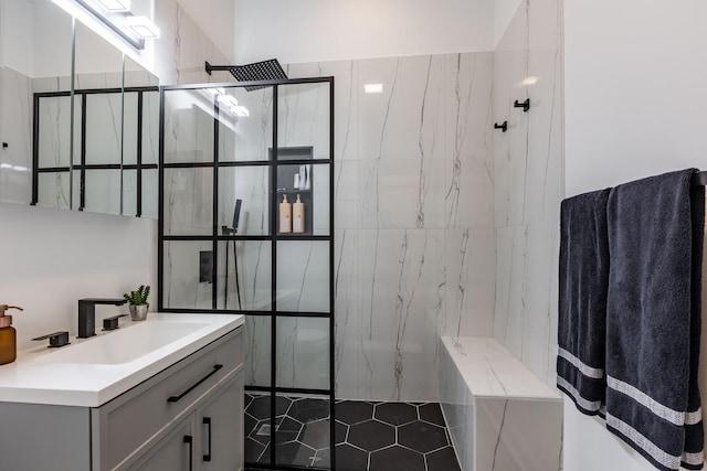 full bath featuring a marble finish shower, vanity, and tile patterned floors