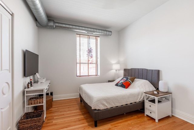 bedroom with baseboards and light wood-style flooring