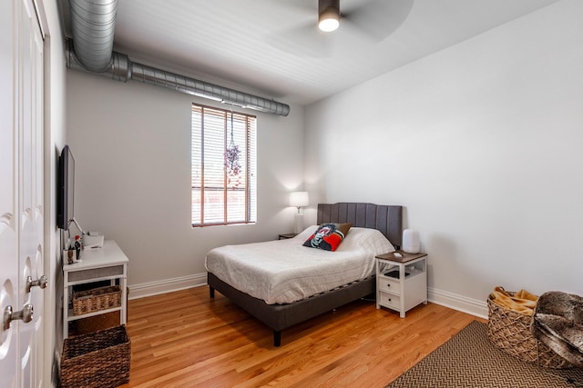 bedroom featuring light wood-style floors, baseboards, and a ceiling fan