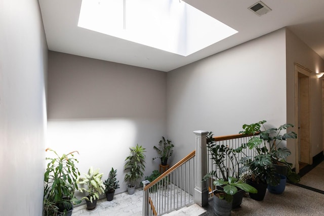 stairway featuring visible vents and a skylight