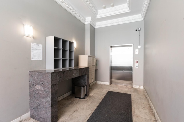 bathroom featuring baseboards, ornamental molding, stone tile floors, and elevator